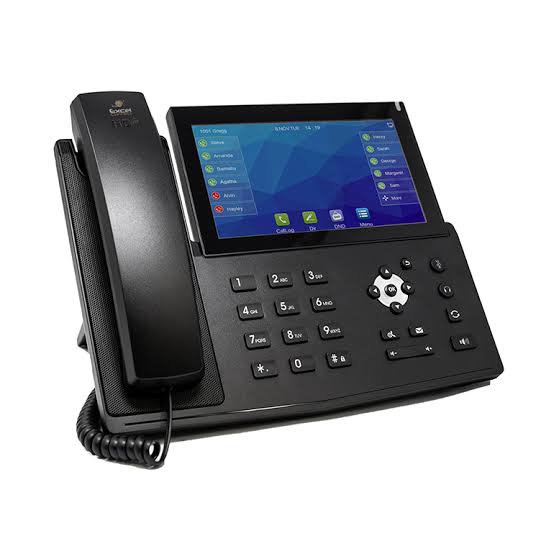 Close-up of a modern VoIP desk phone and headset on a tidy office desk.